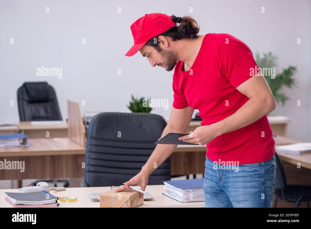 Young courier delivering post to the office Stock Photo Alamy