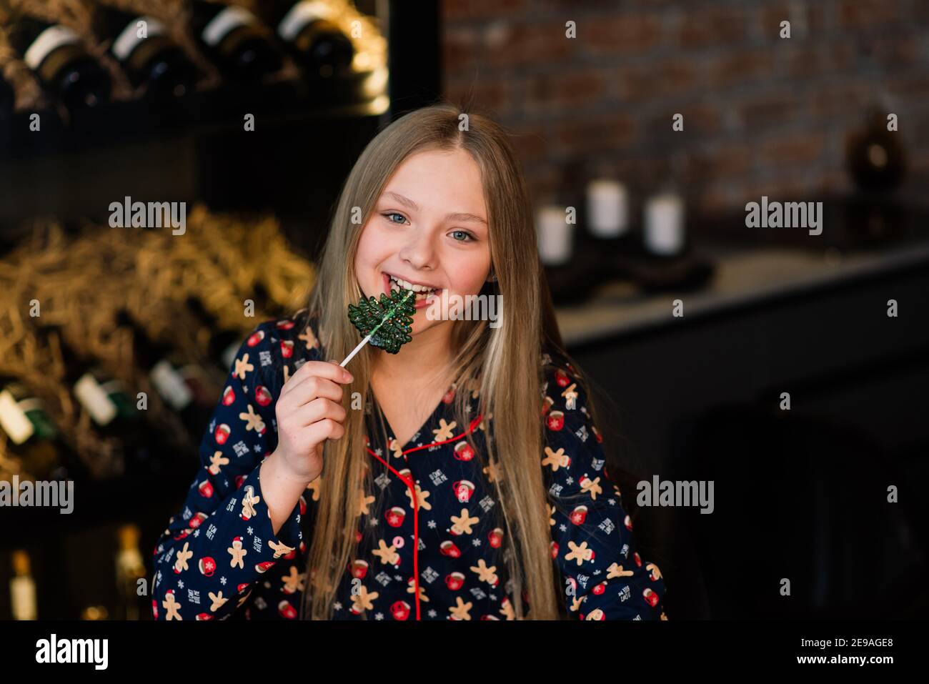 Amazed funny kid lick candy lollipop at home during winter holidays Stock Photo