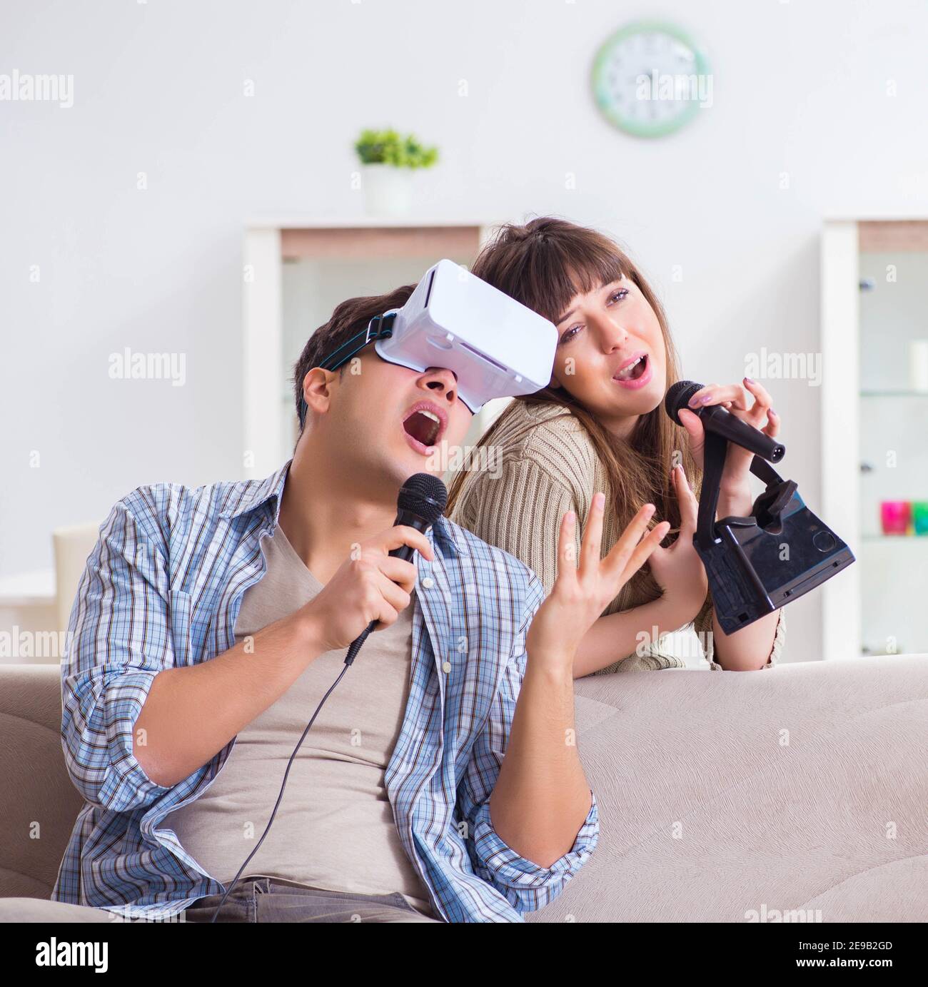 The pair singing karaoke with virtual reality glasses Stock Photo - Alamy