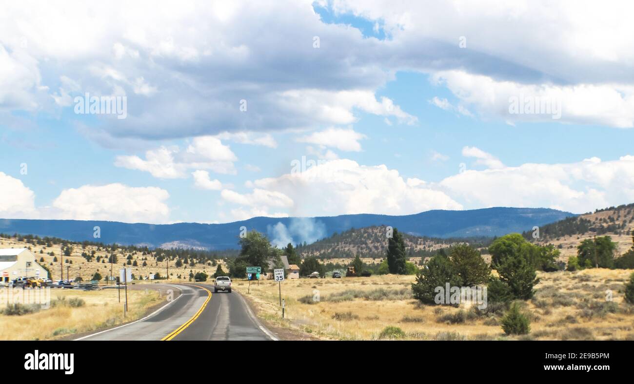 Fire in the distance in Northern California - Driving on 2-lane road near Susansville with mountains and smoke in the distance - selective focus Stock Photo