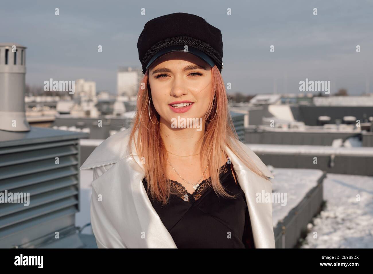 Beautiful confident young female engineer architect designer on rooftop of construction site looking at camera and smiling. Close-up photo Stock Photo