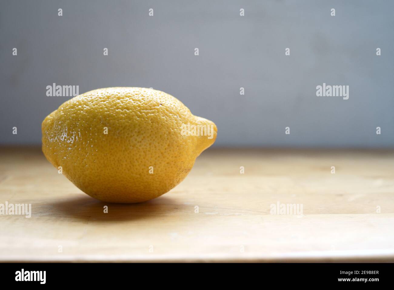 Portrait of fresh and organic ingredients: The lemon, a common used household flavor enhancer. Yellow and roughed texture. Stock Photo