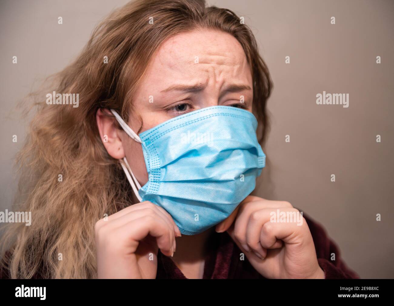 White woman wearing double face masks for covid prevention, blonde hair, front view Stock Photo