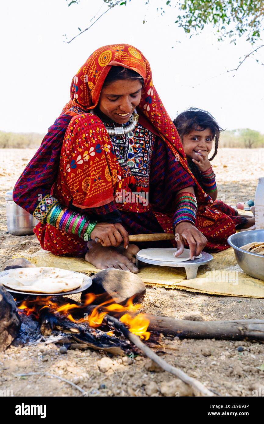 Fakirani woman from Kutch district making chapatis with daughter Stock Photo