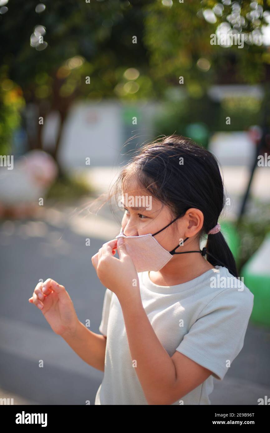 A girls wearing the reusable cotton masks to protect from COVID-19 Stock Photo