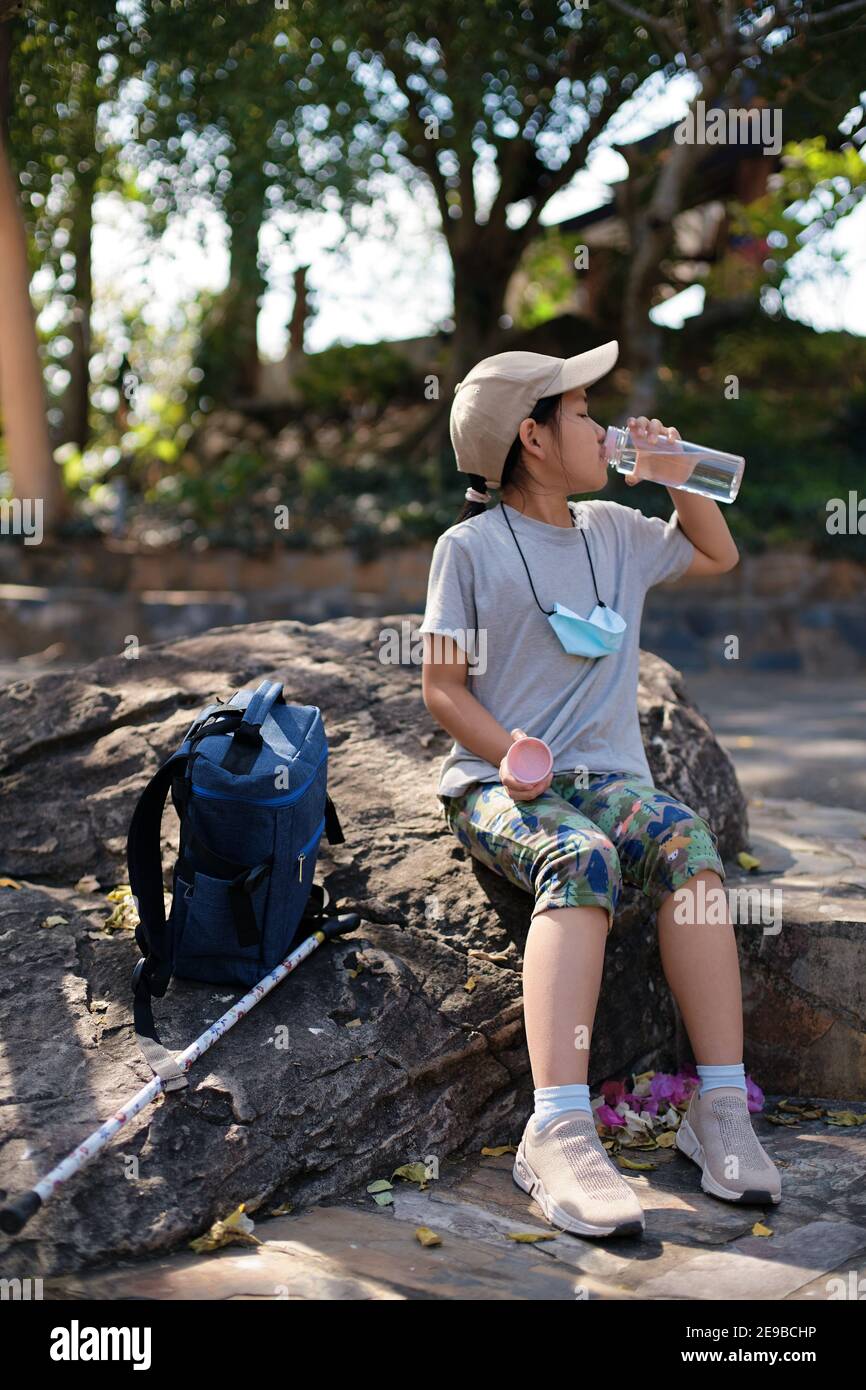 A girl resting on the rock during a weekend hiking Stock Photo