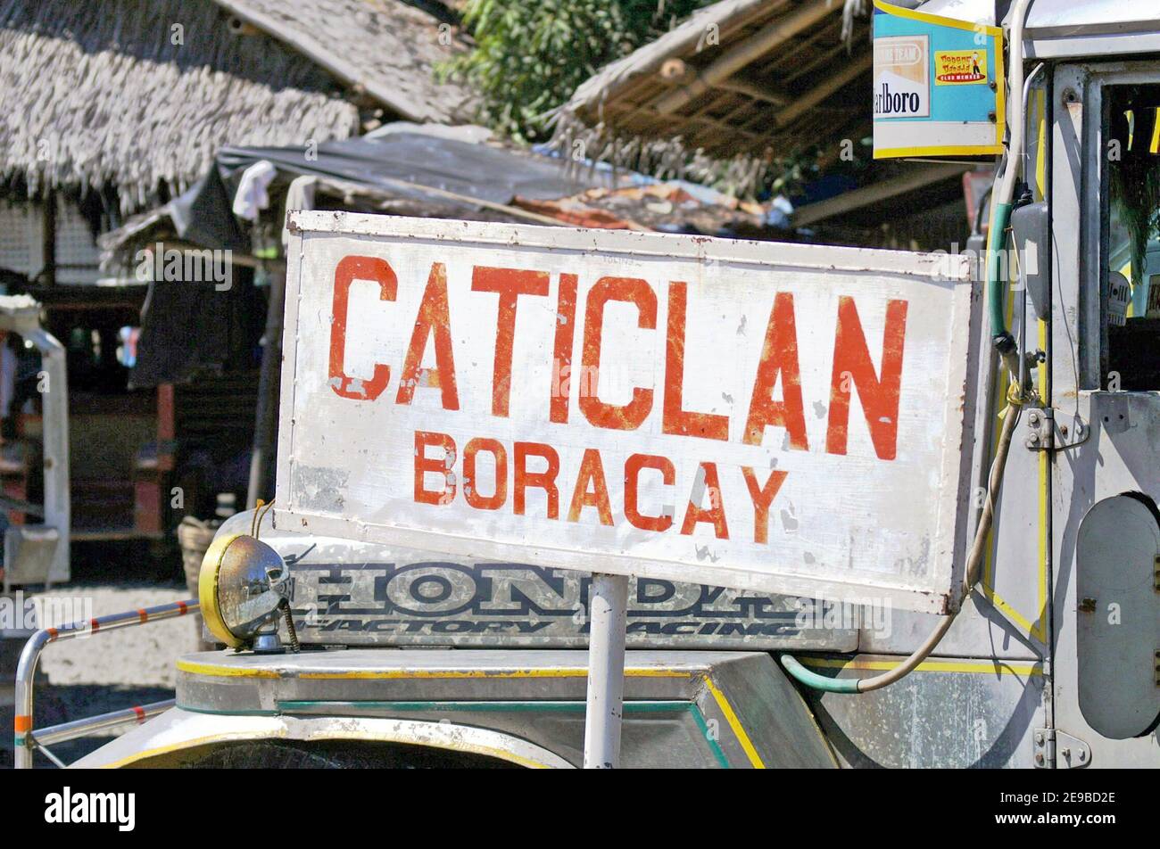 Caticlan, Boracay sign posted in front of a parked Philippines Jeepney indicates the transportation hub for land to see transport in Caticlan, Aklan, Philippines.  The majority of visitors to Boracay take a Jeepney or bus to Caticlan where they catch a banca to the resort island of Boracay. Stock Photo