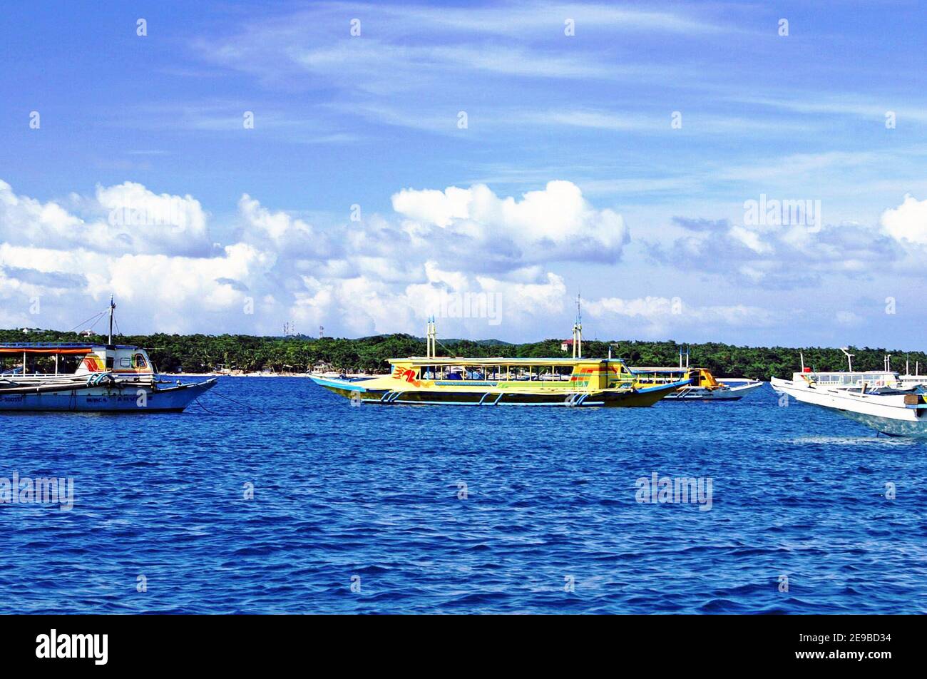 Boat and ferry traffic fills the waters near the Caticlan Jittney Port, the main departure/arrival for people visiting the resort island of Boracay, Philippines.  Taken in 2005, signs of unsustainable tourism were appearing such as transportation congestion contributing to water pollution.  In 2018 the government closed down the entire island of Boracay due to its degradation and pursued a rehabilitation and recovery plan based on sustainable tourism models.  The quantity of seacraft transportation to and from the island has impacts on the environment as well as the island carrying capacity. Stock Photo