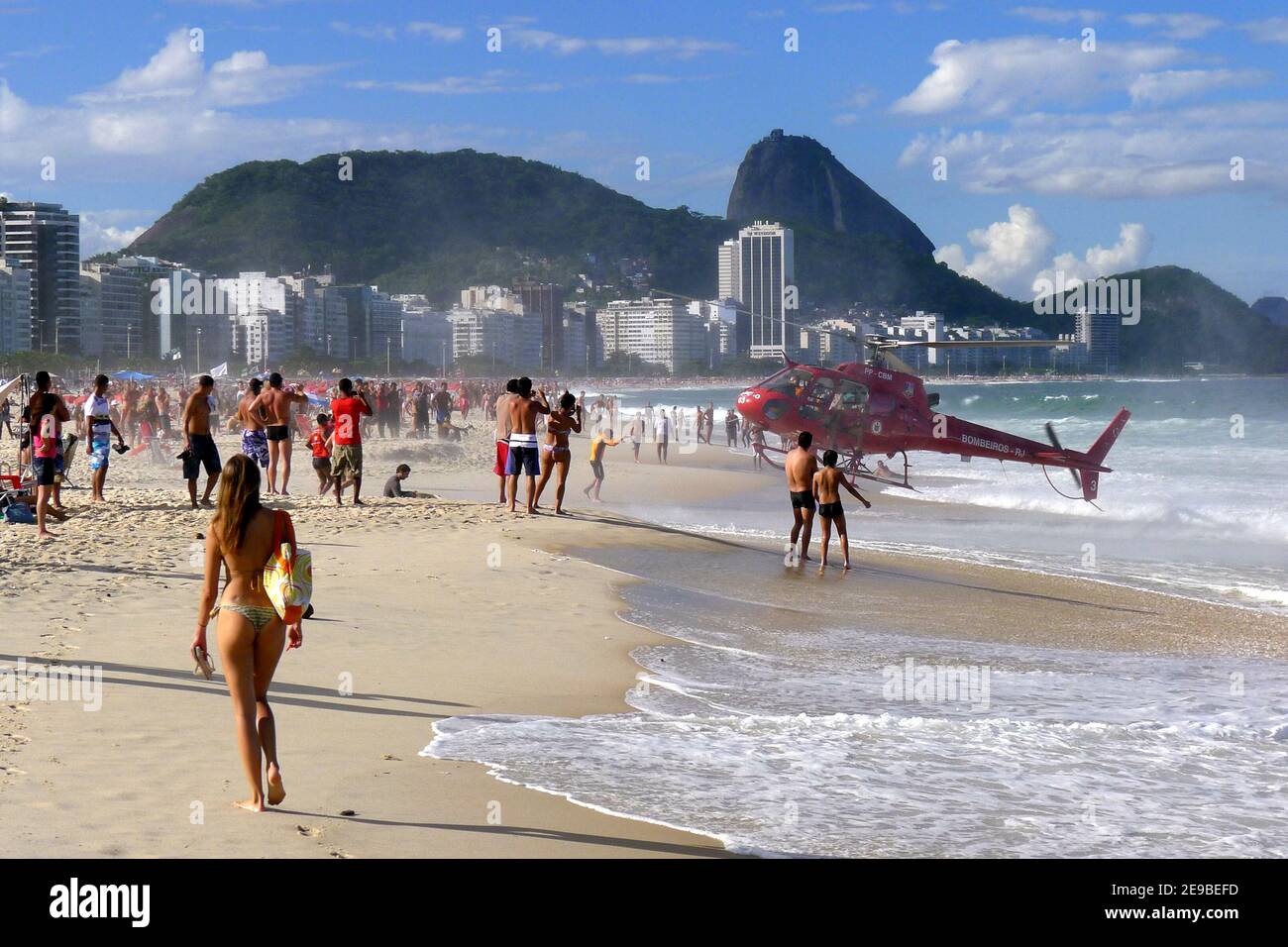 A helicopter lands on Copacabana Beach at Rio de Janeiro in Brazil after rescuing a person from the Atlantic Ocean surf. Stock Photo