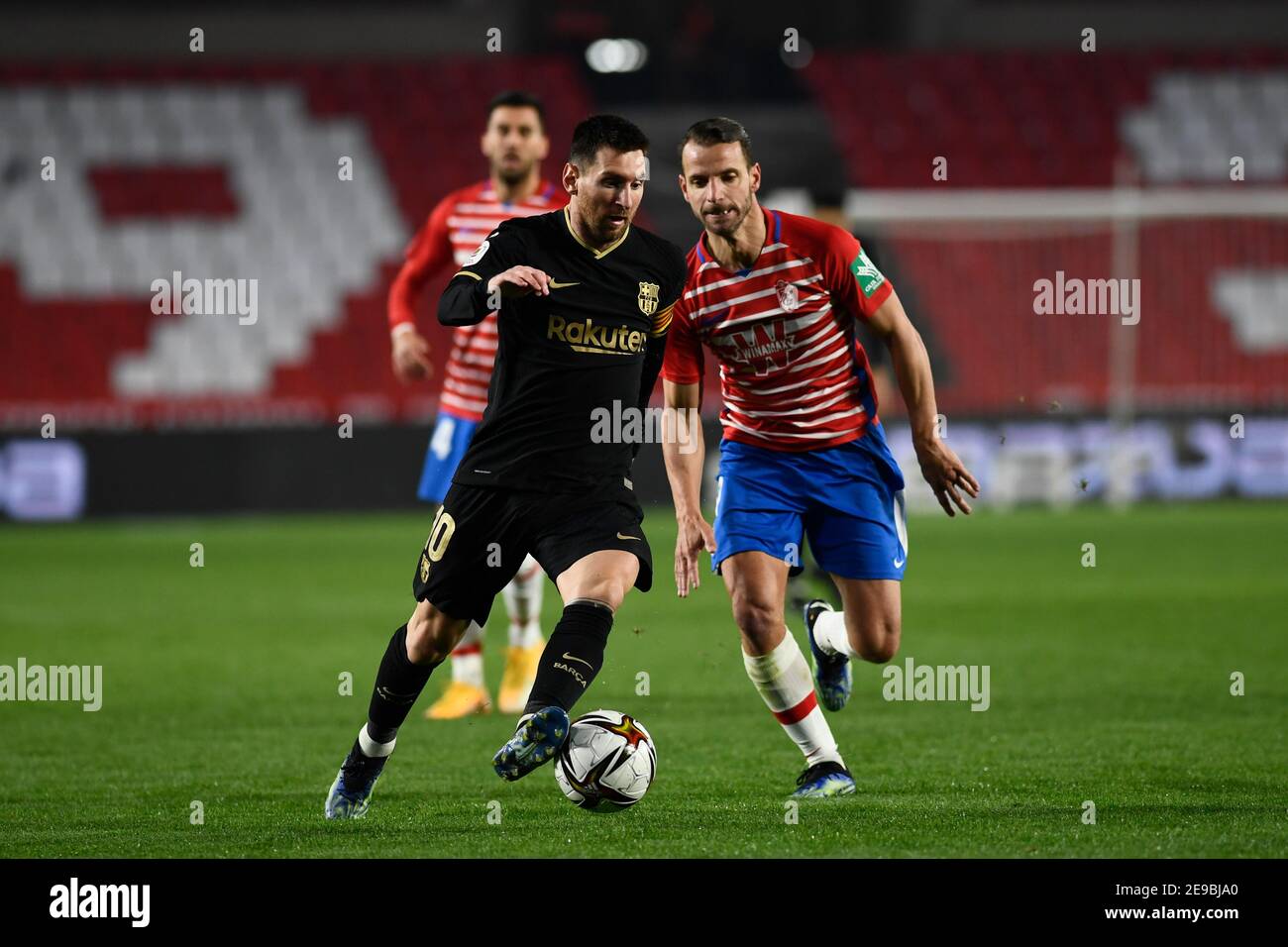 Granada, Spain. 03rd Feb, 2021. Lionel Messi of FC Barcelona and Roberto Soldado of Granada CF in action during the Copa del Rey Quarter-final match between Granada CF and FC Barcelona at Nuevo Estadio de Los Cármenes.Final Score: Granada CF 3:5 FC Barcelona. Credit: SOPA Images Limited/Alamy Live News Stock Photo