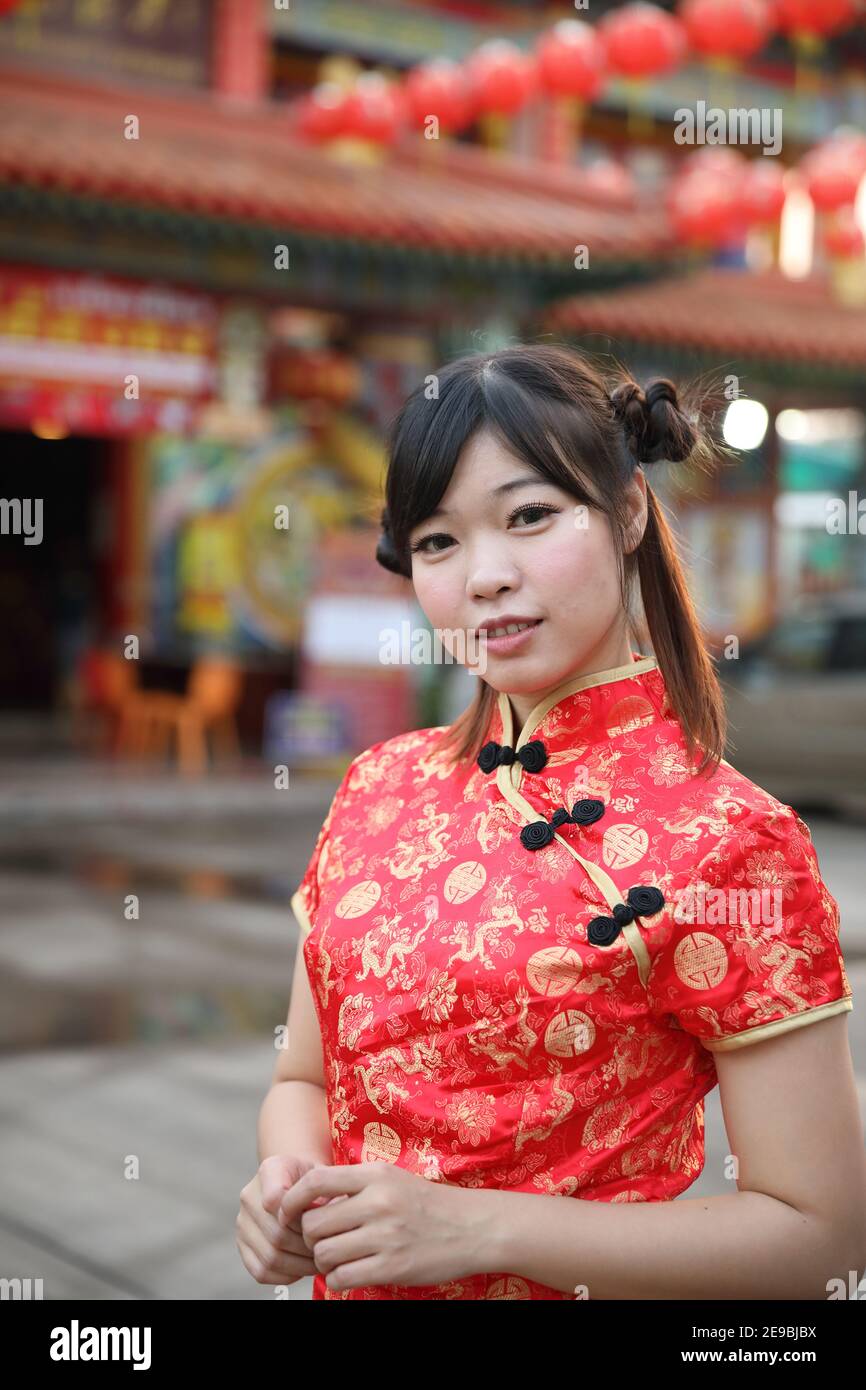 beauty woman wear red cheongsam looking and smile in chinese new year Stock Photo