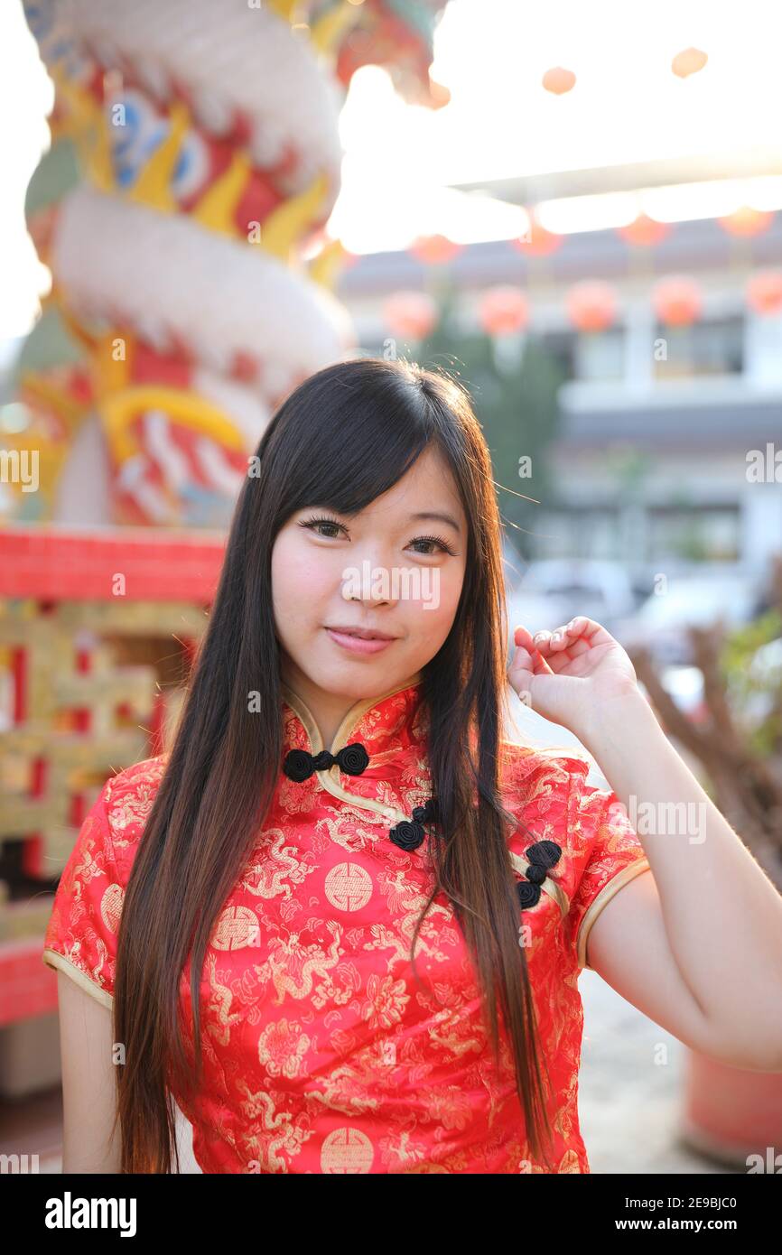 beauty woman wear red cheongsam looking and smile in chinese new year Stock Photo