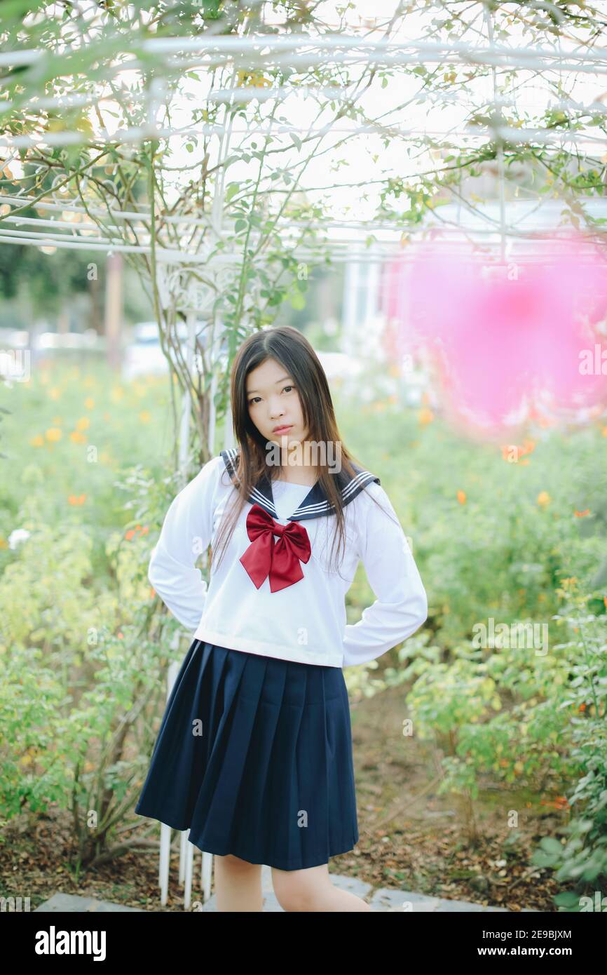 school girl costume at park outdoor with flowers garden background Stock Photo