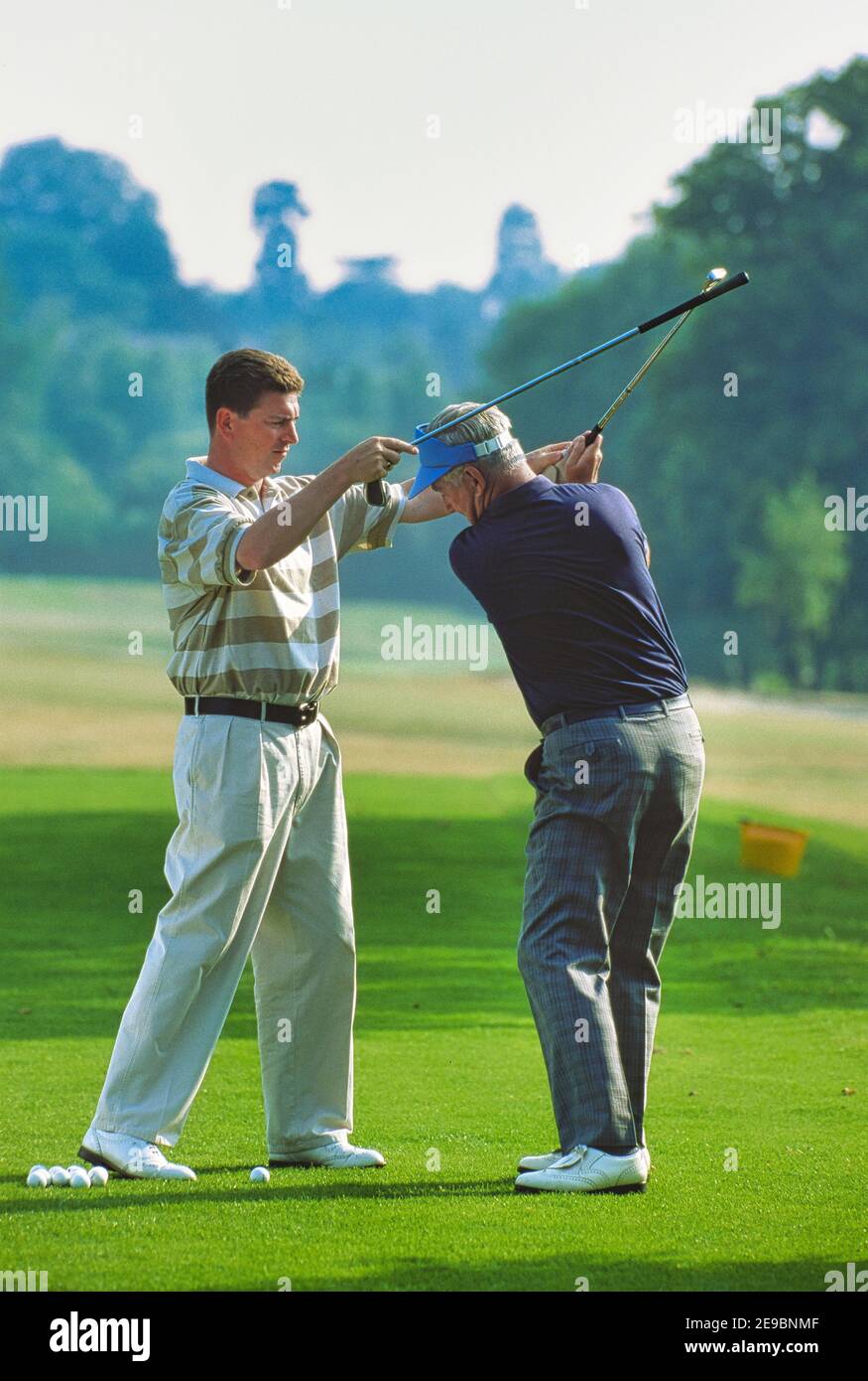 Golf professional helping mature amateur with his golf swing - Wimbledon,  London. Photographjer holds model releases Stock Photo - Alamy