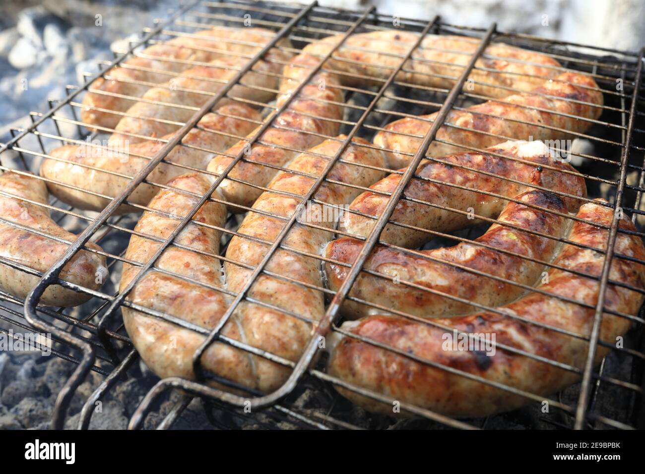 Cooking sausages on grill at a picnic Stock Photo Alamy