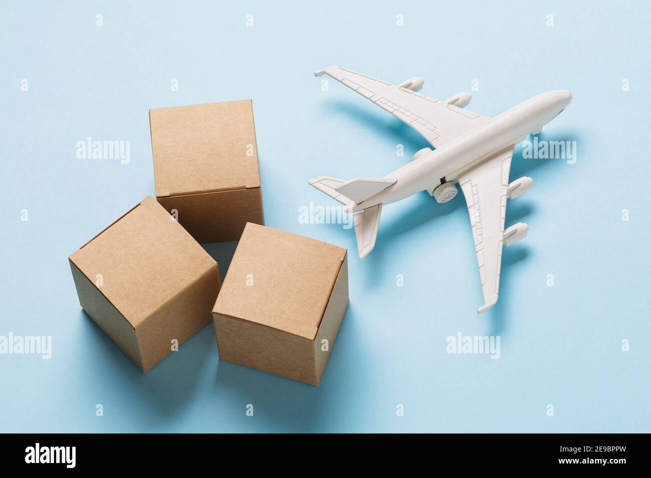 Toy plane and cardboard boxes on a blue background. Cargo delivery