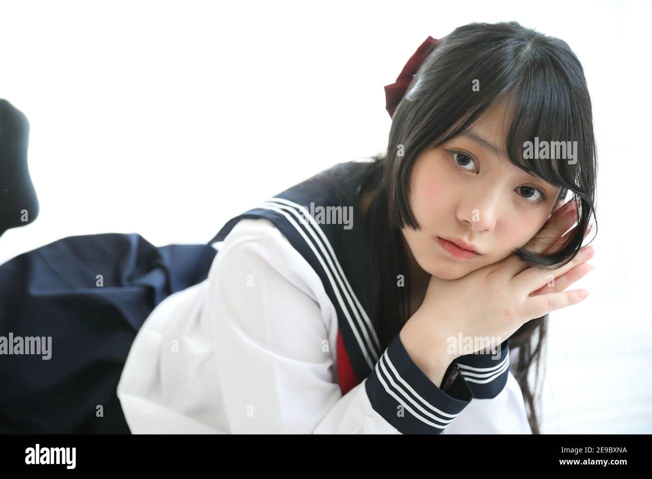 Portrait japanese school girl sleeping in white tone bed room Stock Photo. 