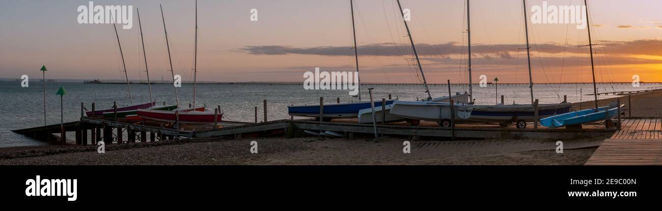 Panorama view of dinghies on a jetty at Thorpe Bay with Southend Pier in the background Stock Photo