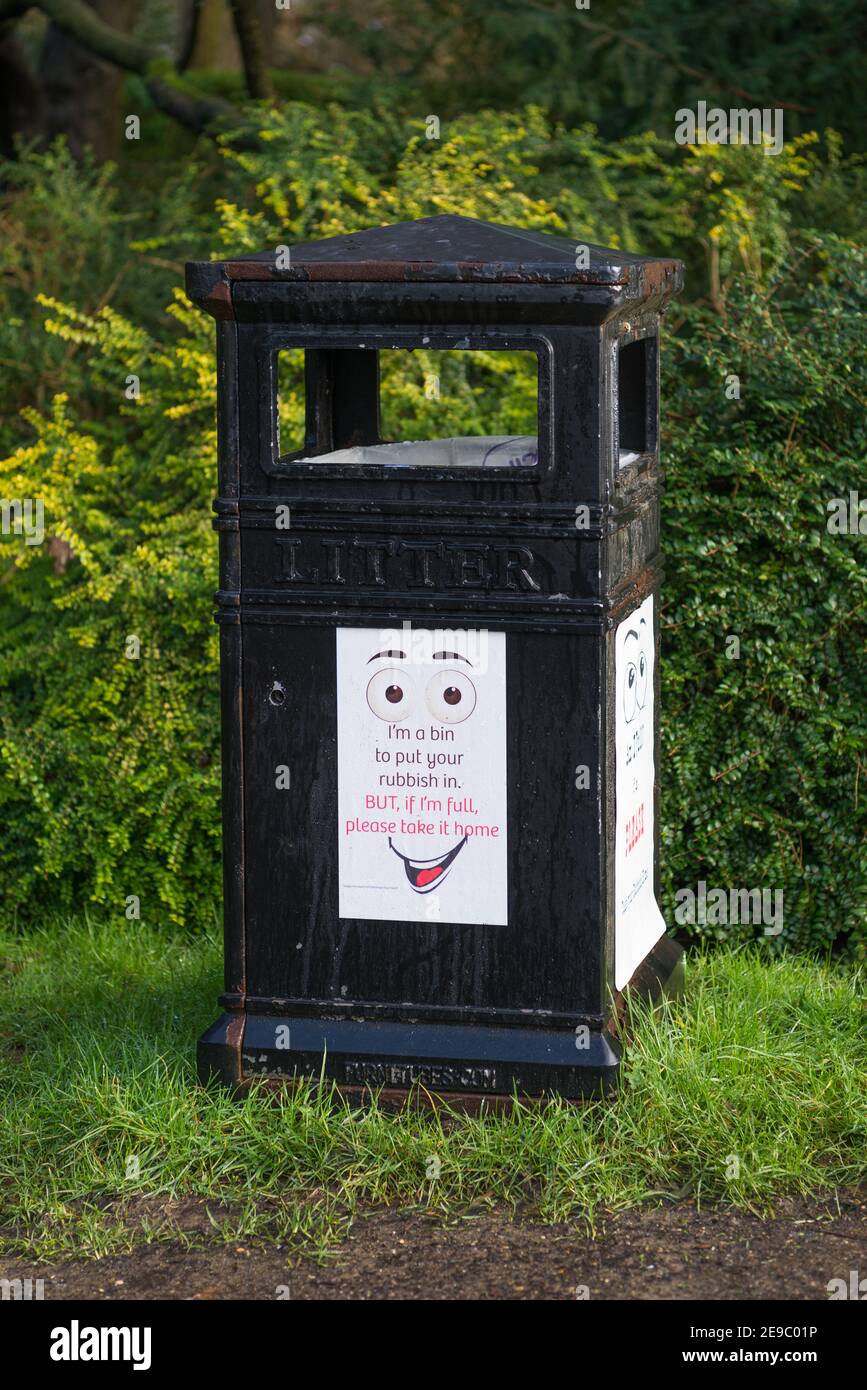 Litter bin in Pinner Memorial Park with poster requesting people to take their litter home if the bin is full. Stock Photo