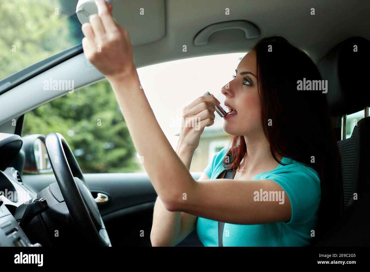woman putting on make up in her car Stock Photo