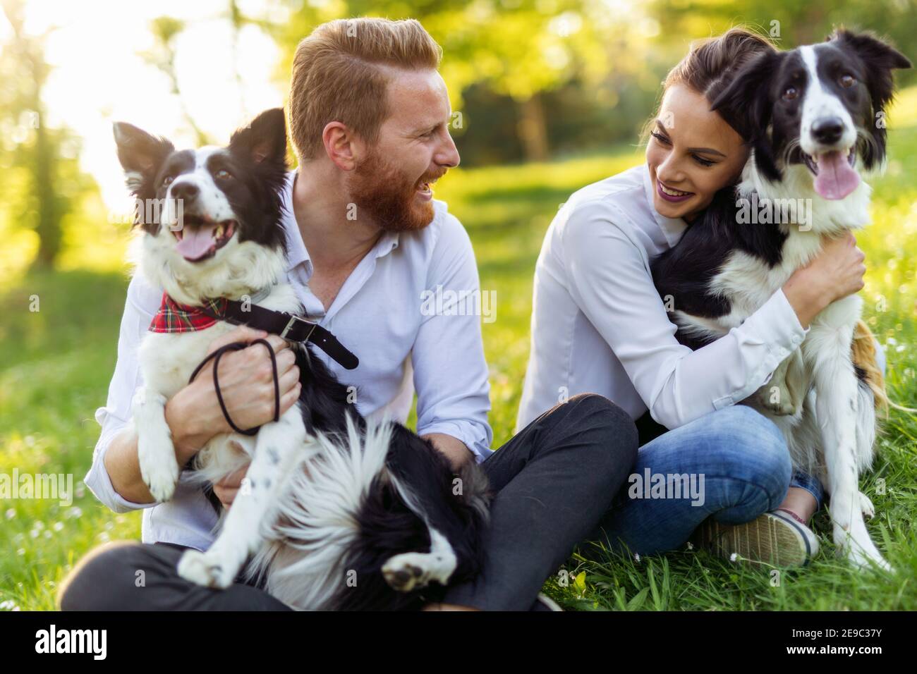 Happy young couple walking, playing with dogs in a park Stock Photo - Alamy