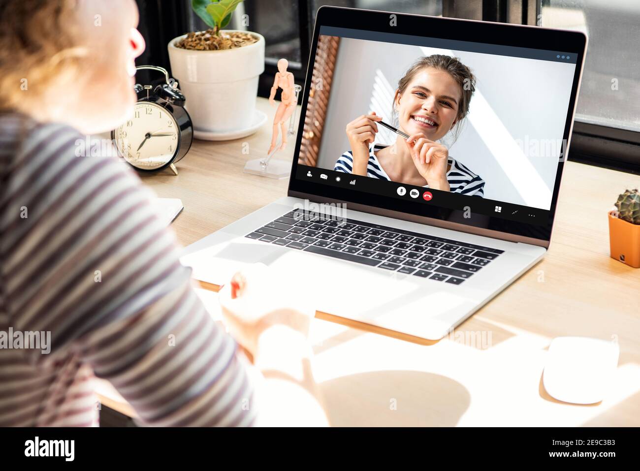 Smiling happy Caucasian woman chatting with female friend via online video call meeting using laptop computer in the time of pandemic, work from home Stock Photo