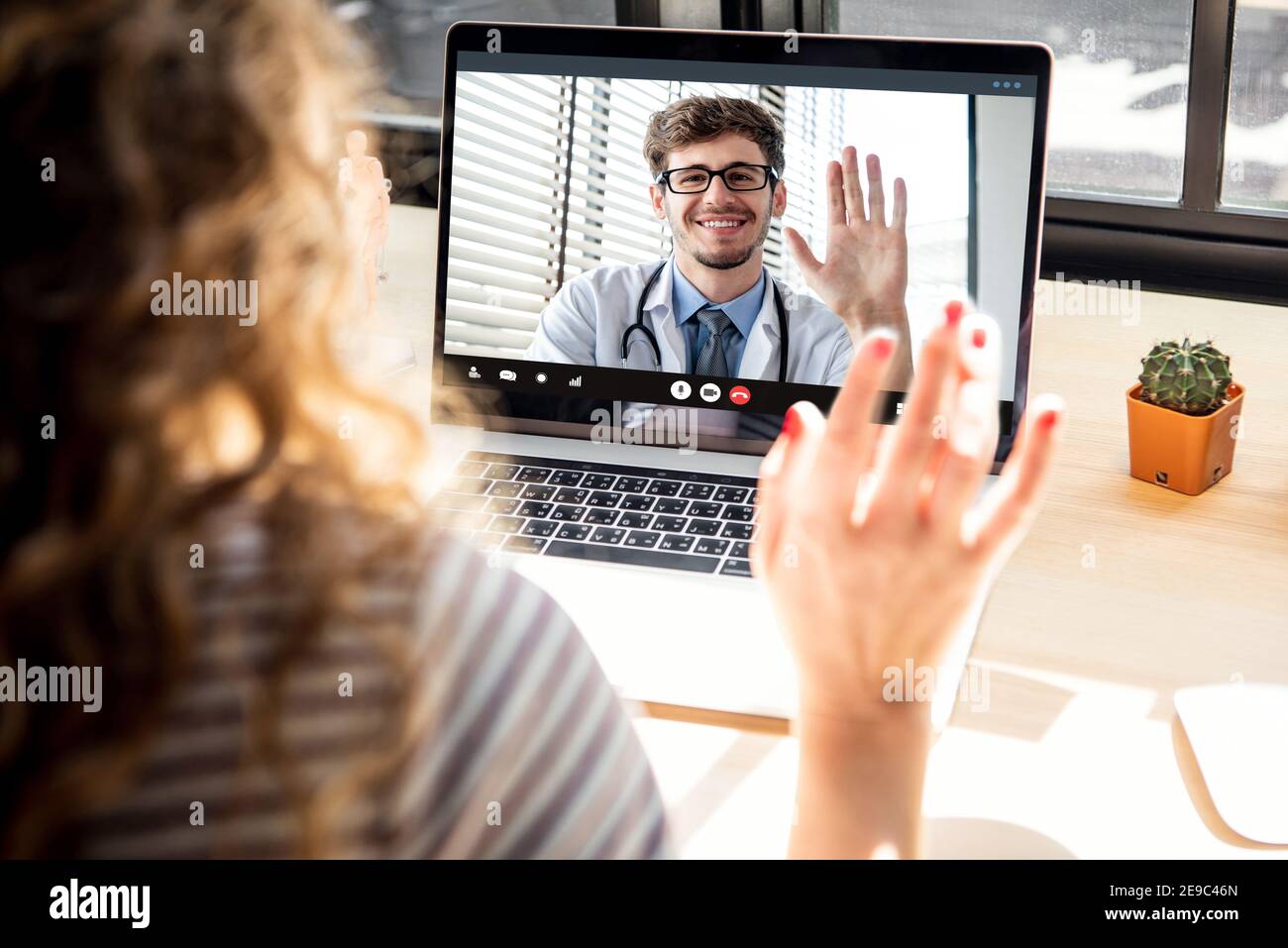 Female patient meeting with doctor via video call on laptop computer at home, medical online service concepts Stock Photo