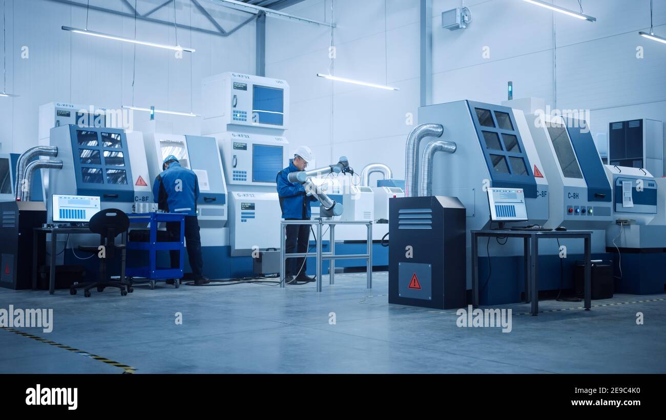 Modern Factory with Professional Workers, Engineers, Managers Working on Production Line, Workshop Management, Optimization. Industrial Facility Stock Photo