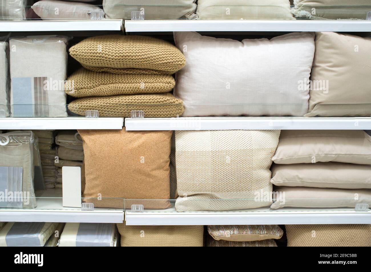 Bright pillows and bed wear on shelves. Selective focus. Stock Photo