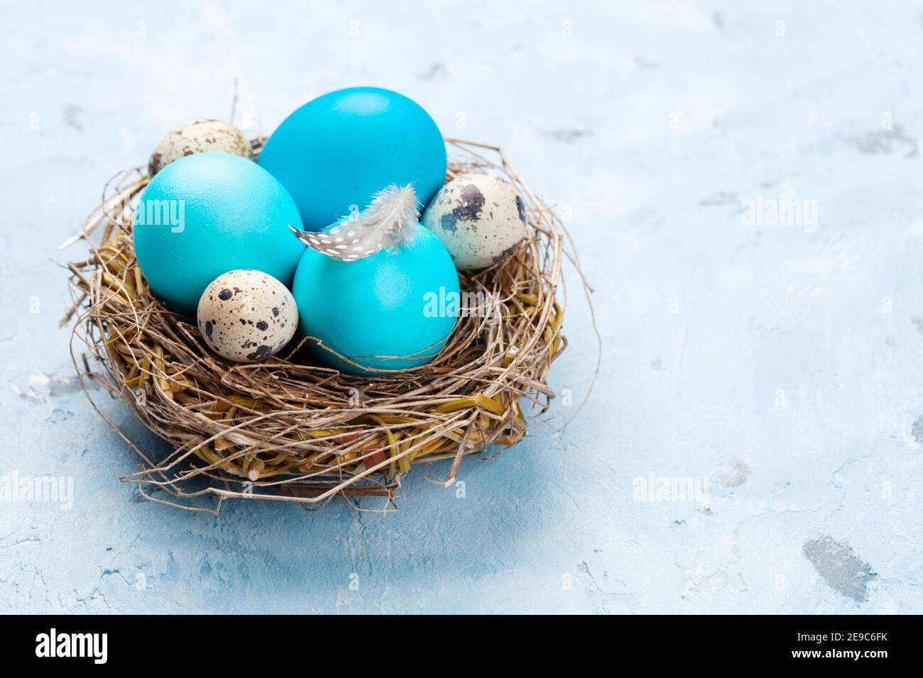Colorful easter eggs in nest on stone background. With space for your ...