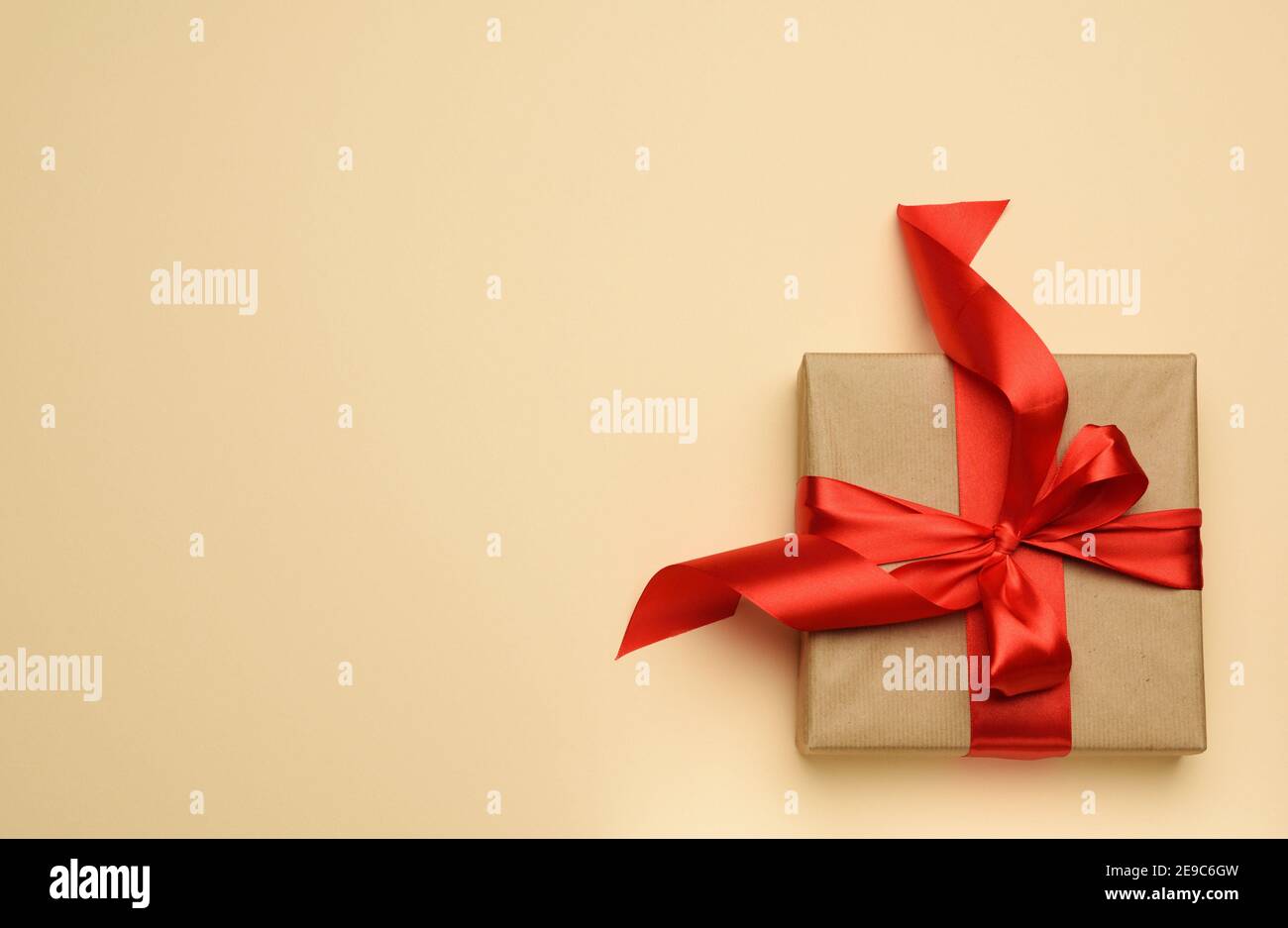 square gift box is packed in red paper and curled silk ribbon, festive  background, top view Stock Photo - Alamy