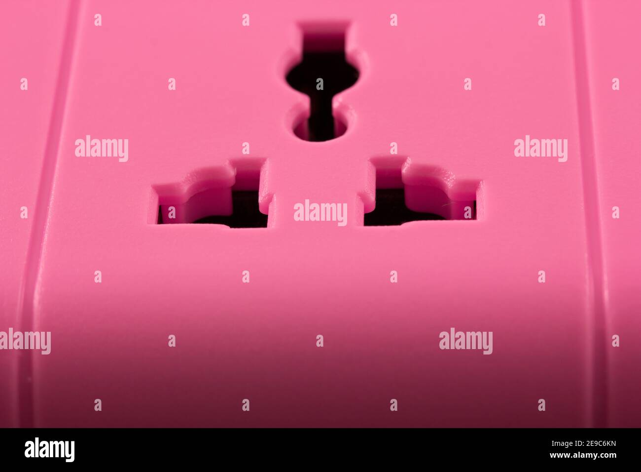 Closeup picture of a pink outlet isolated on black. Electric Power Line ...