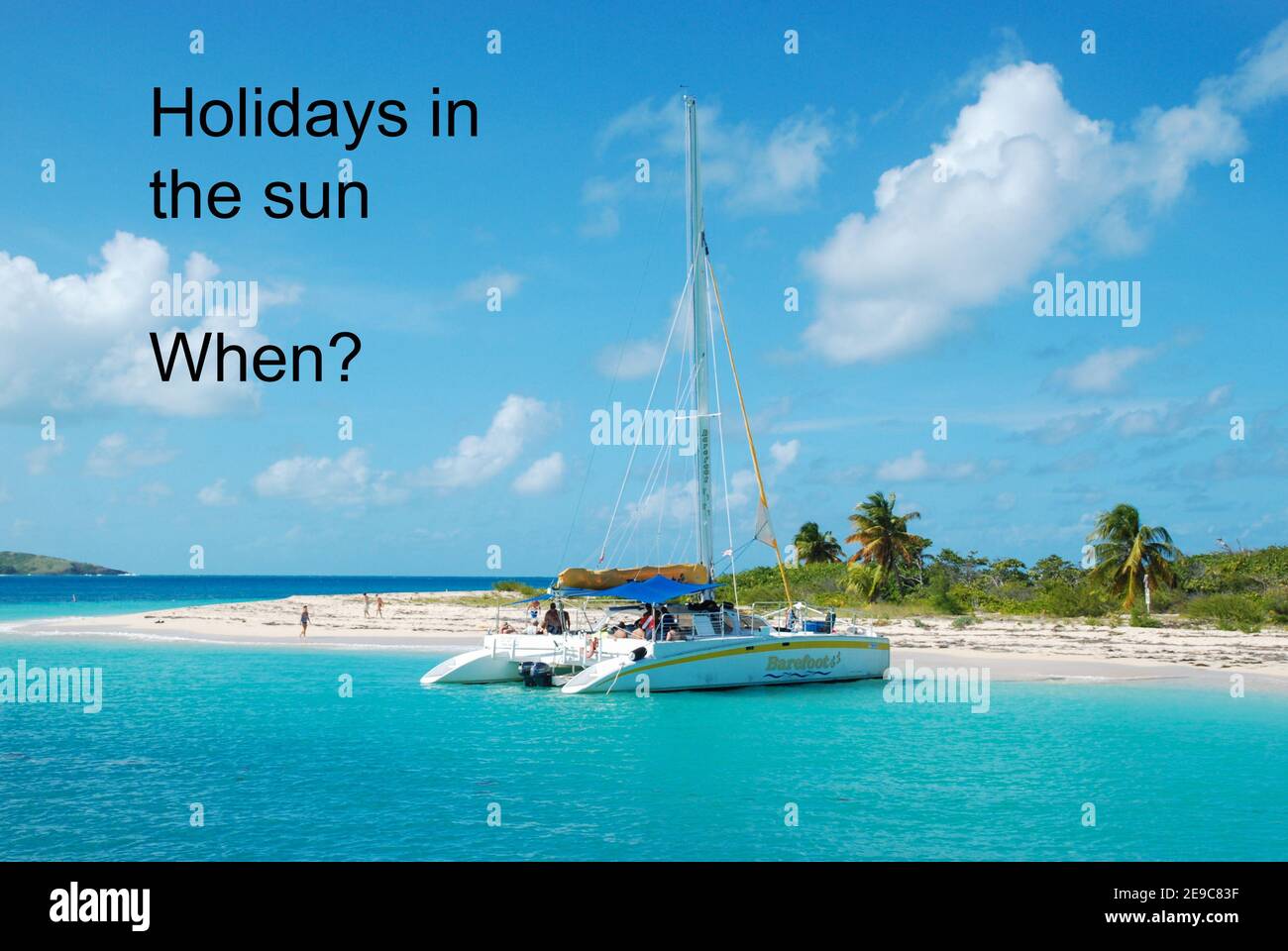 Concept image. When will holidays in the sun be allowed during the coronavirus covid-19 pandemic lockdown. Tropical island, beach and catamaran. Stock Photo