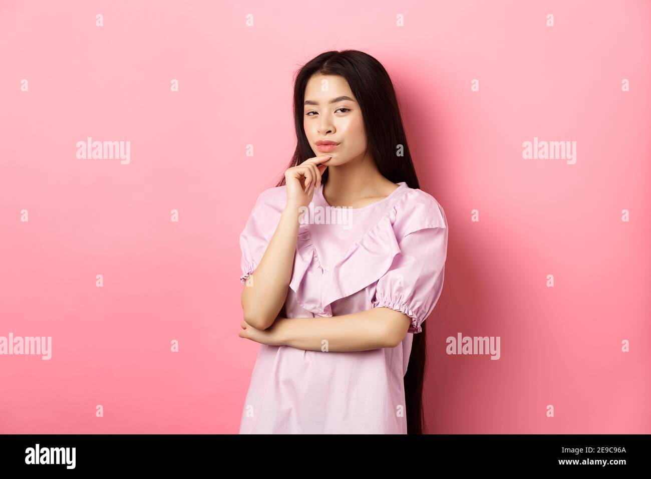 H.M.M. asian Hmm, interesting. Pensive and cunning asian girl having idea, plan to do  something, looking at camera and touching chin with thoughtful face,  standing Stock Photo - Alamy