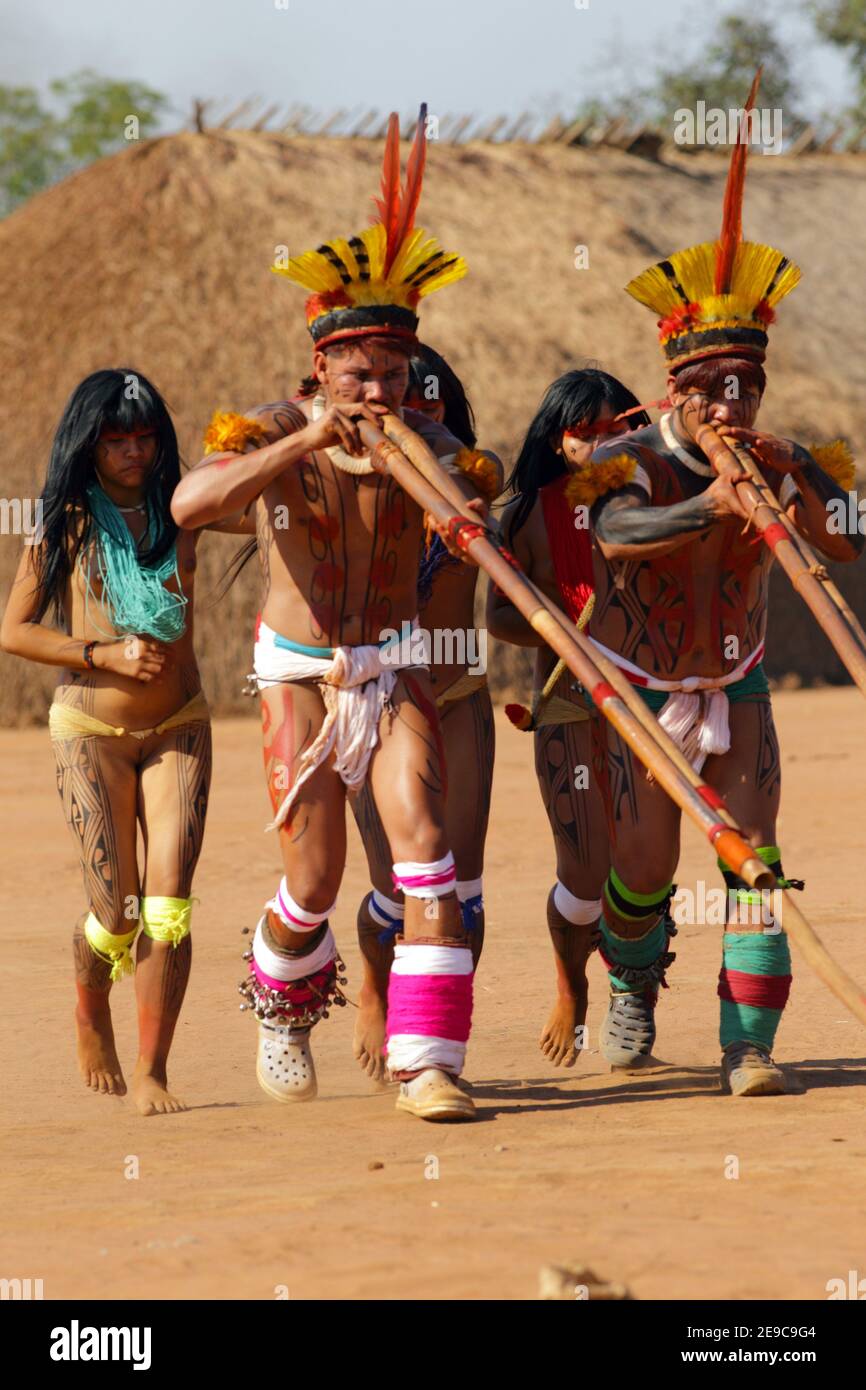 Two native indios with two young girls in festive clothing and feathres in  their hair playing their long pipe, Mato Grosso, Brazil, South America  Stock Photo - Alamy