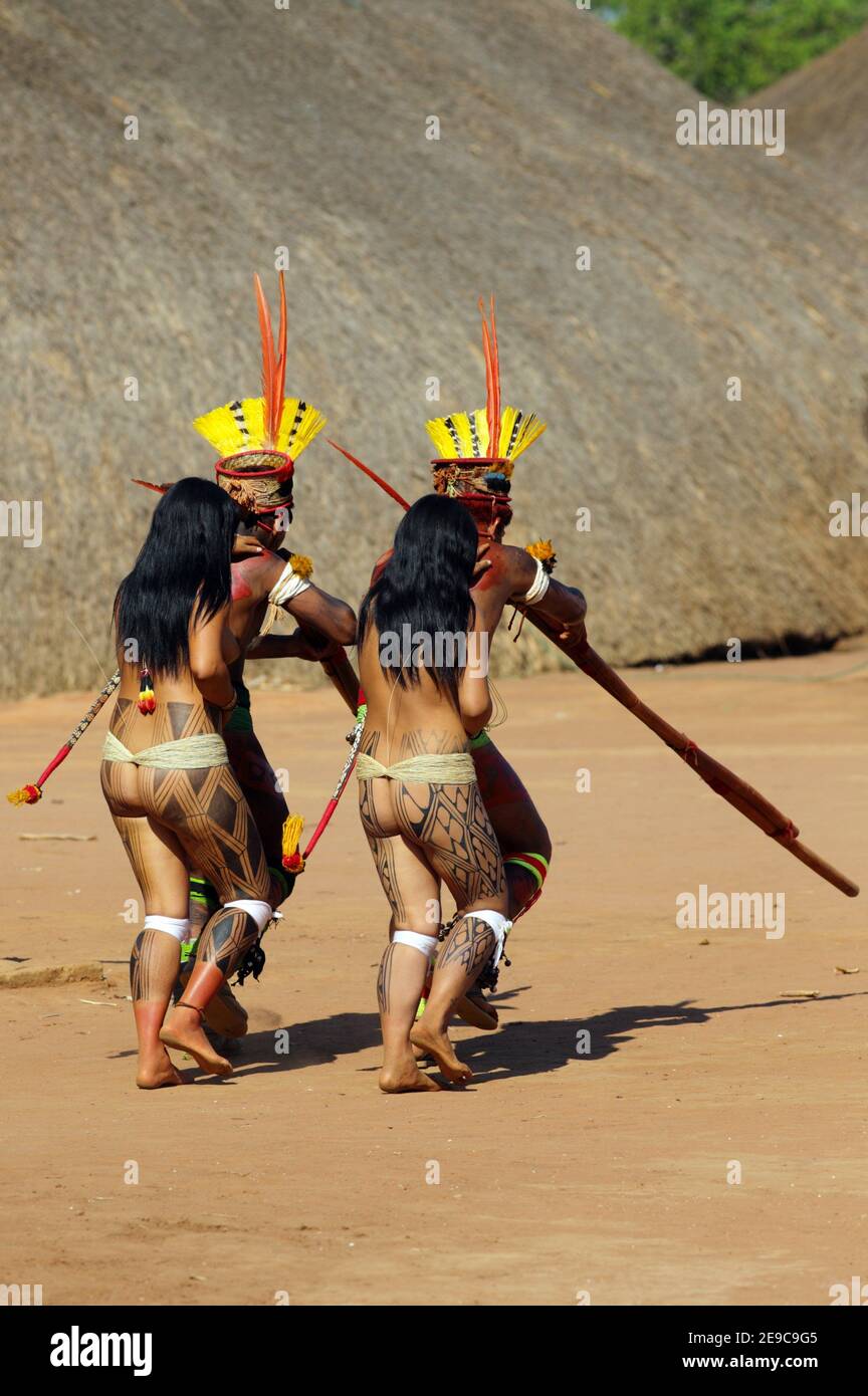 Two native indios with two young girls in festive clothing and feathres in  their hair playing their long pipe, Mato Grosso, Brazil, South America  Stock Photo - Alamy