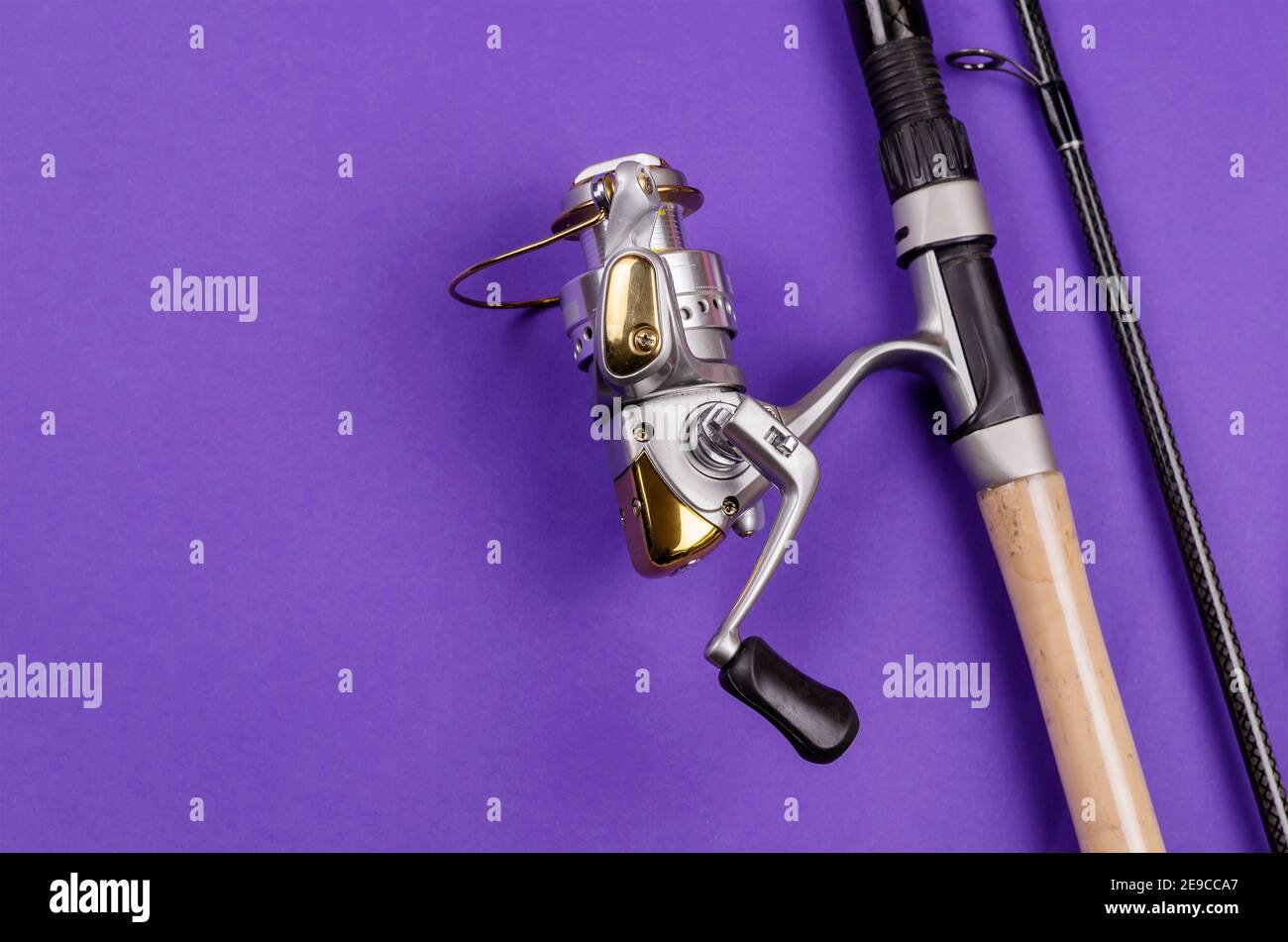 Fishing rod with attached fly fishing reel on blue background. Fishing,  tackle, sport. Selective focus Stock Photo - Alamy