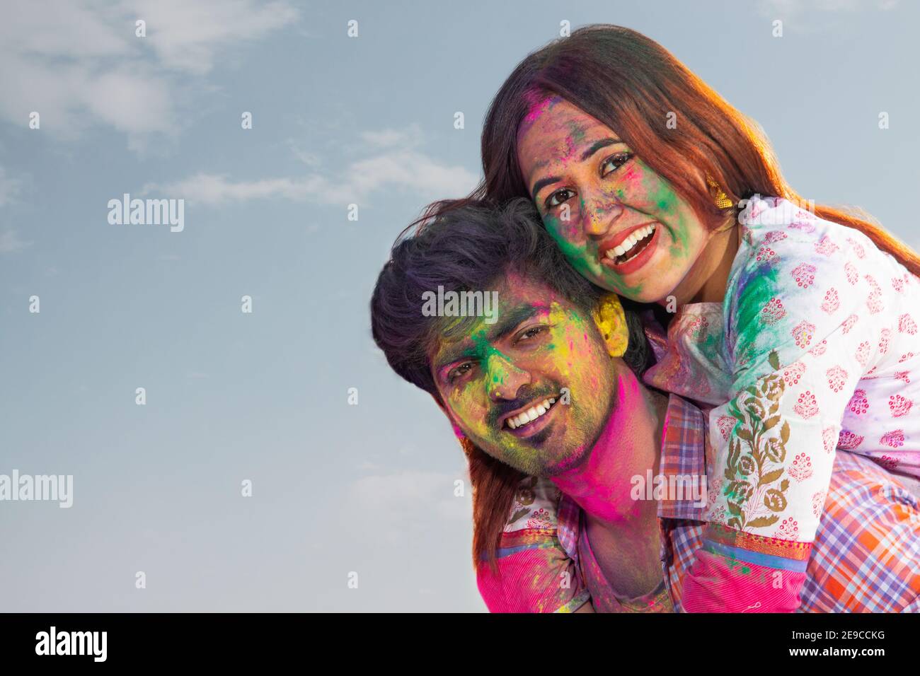 A HAPPY COUPLE POSING TOGETHER WHILE CELEBRATING HOLI Stock Photo
