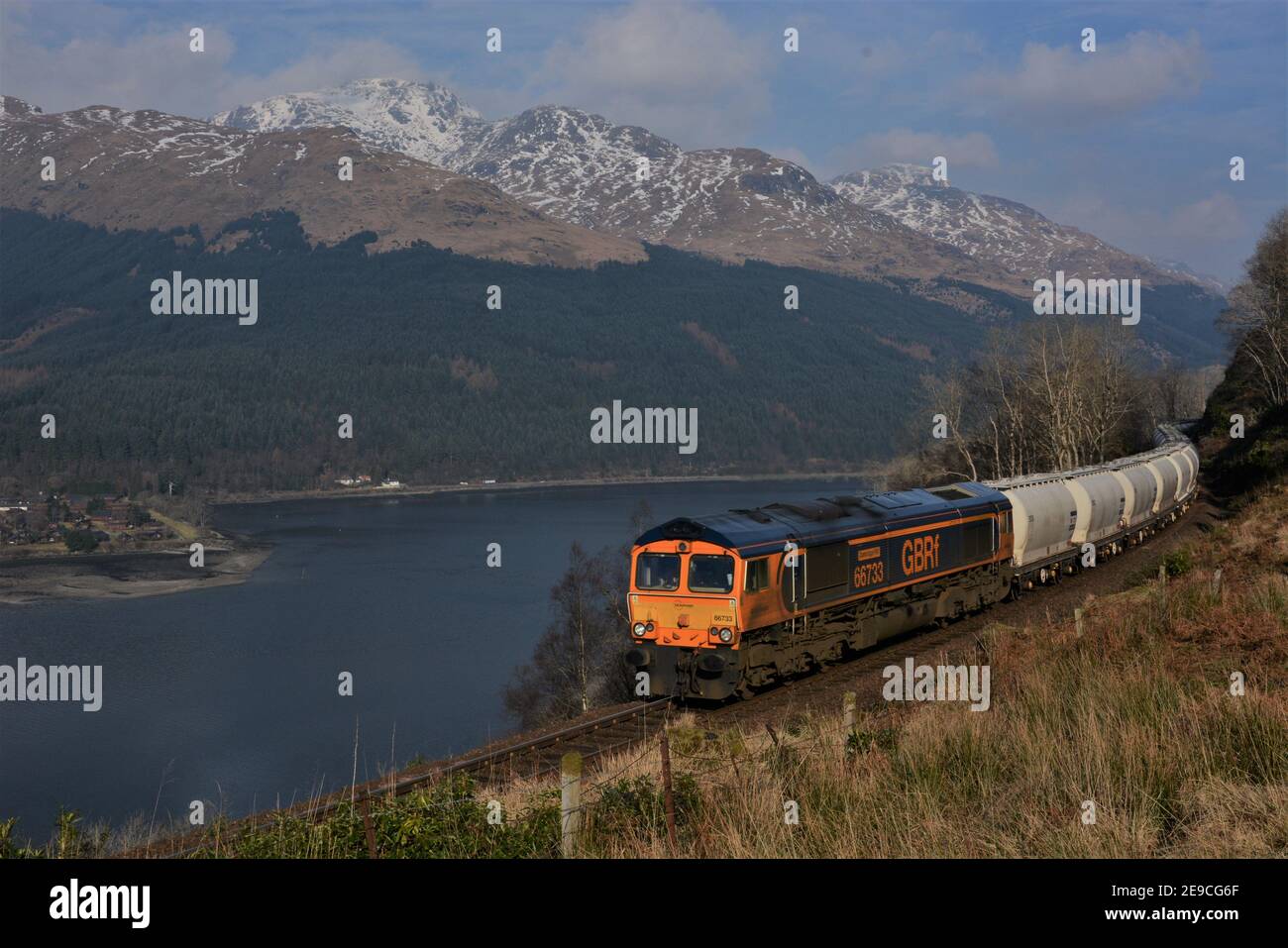 A southbound GBRf Class 66 hauling empty alumina wagons from Fort William to Lynemouth between Arrochar and Glen Douglas. Stock Photo