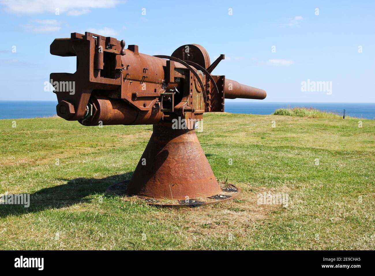 The old rusty naval gun is pointing at the sea. Stock Photo