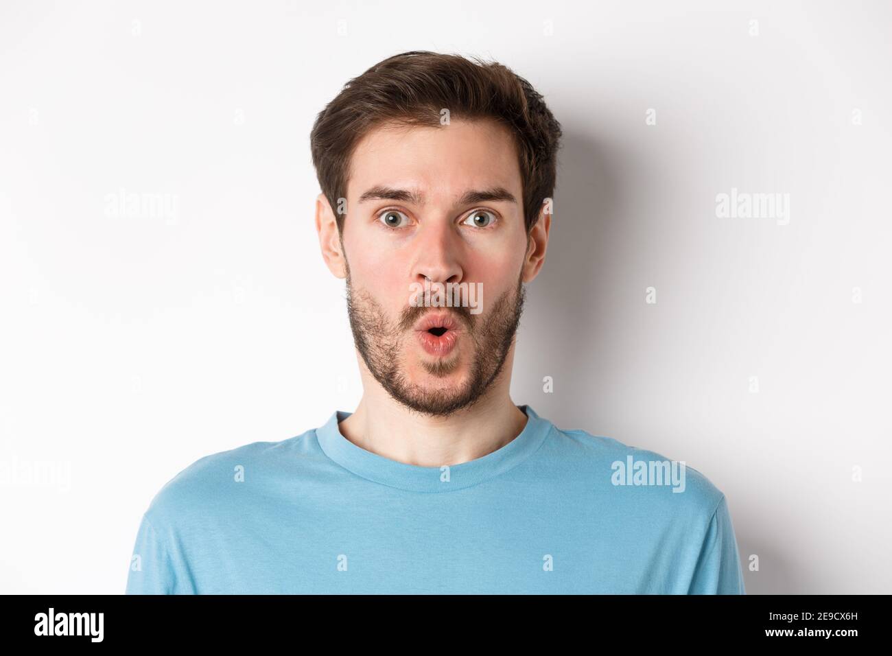 Close-up of surprised man face, saying wow and staring at camera amazed ...