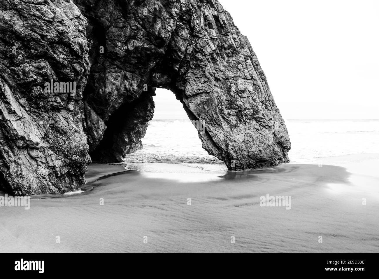 Beautiful stone natural arche. Rock formation in a beach with ocean in background. Stock Photo