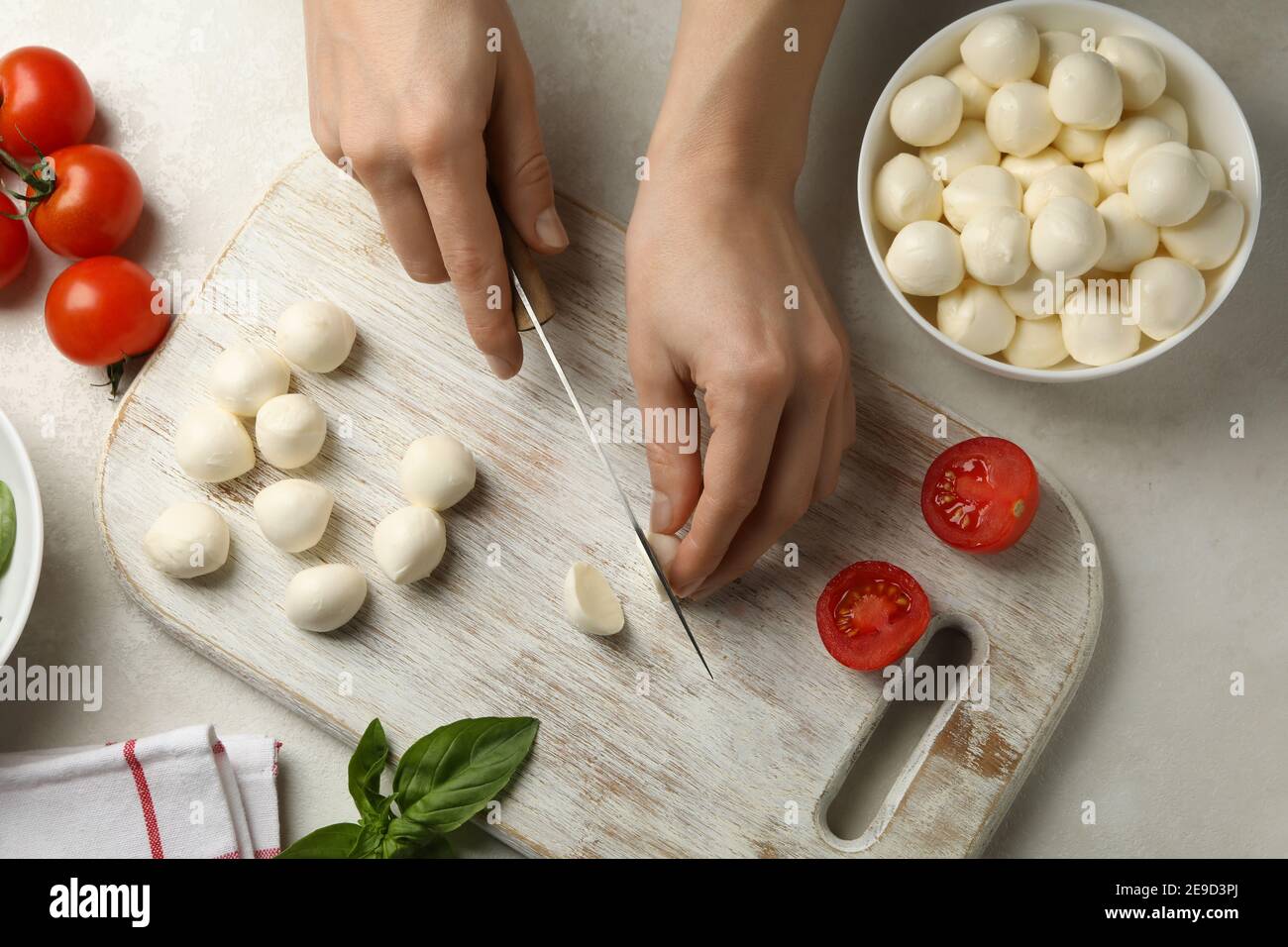 Woman slicing mozzarella on cutting board, top view Stock Photo Alamy