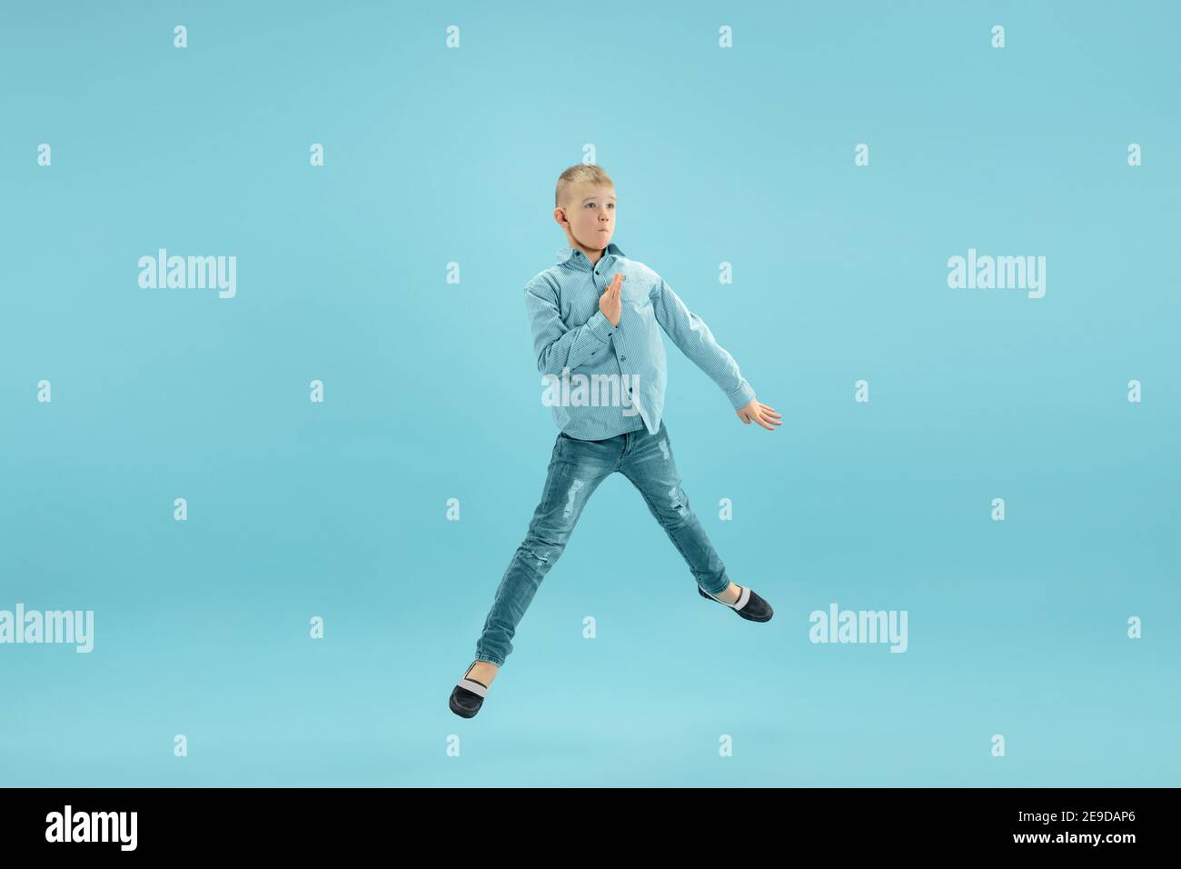 Jumping high. Childhood and dream about big and famous future. Pretty  little boy isolated on blue studio background. Childhood, dreams,  imagination, education, facial expression, emotions concept Stock Photo -  Alamy