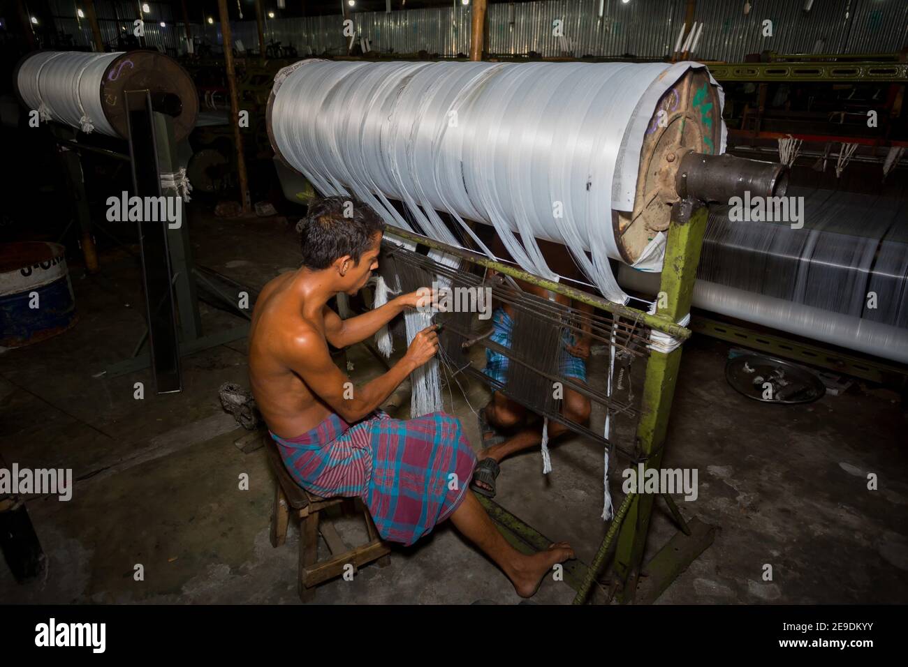 Yarn factory workers are rechecking newly made white yarn at Narsingdi