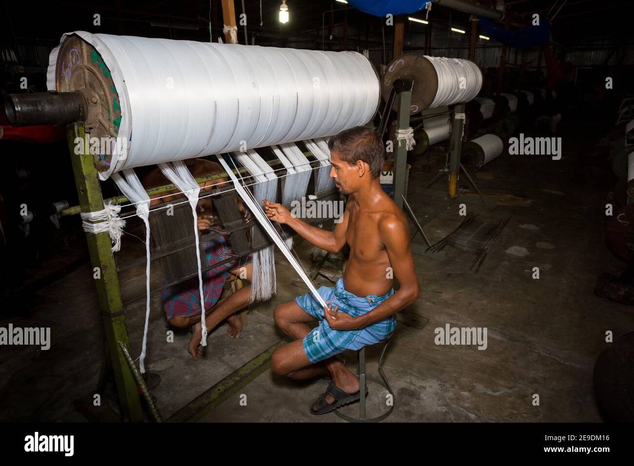 Yarn factory workers are rechecking newly made white yarn at Narsingdi, Bangladesh. Stock Photo