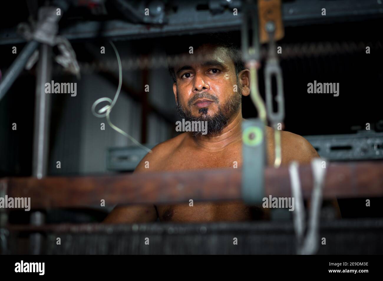 Portrait of a yarn factory worker operating a yarn machine at Narsingdi, Bangladesh. Stock Photo