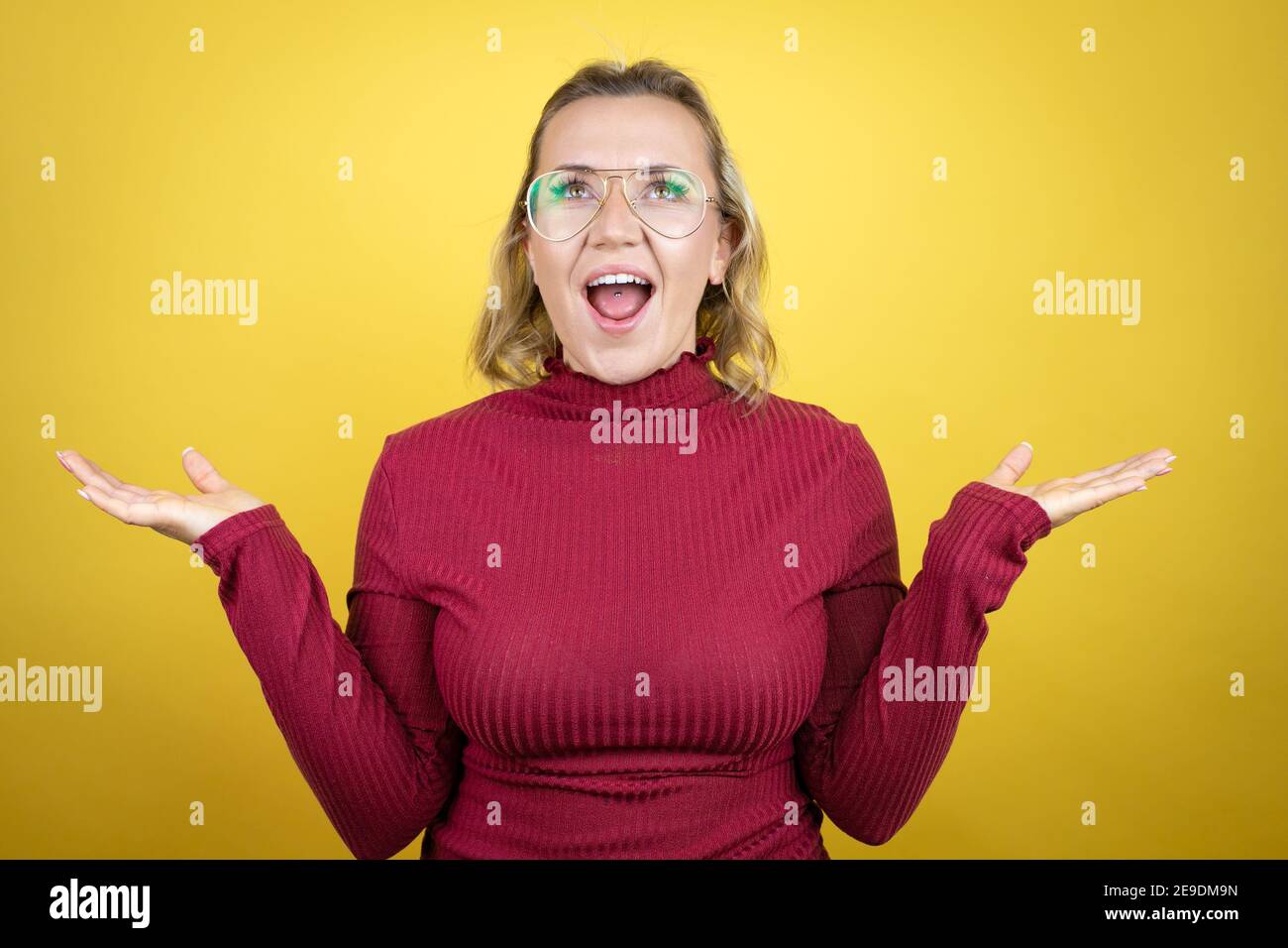 Young caucasian woman wearing casual red t-shirt over yellow background ...