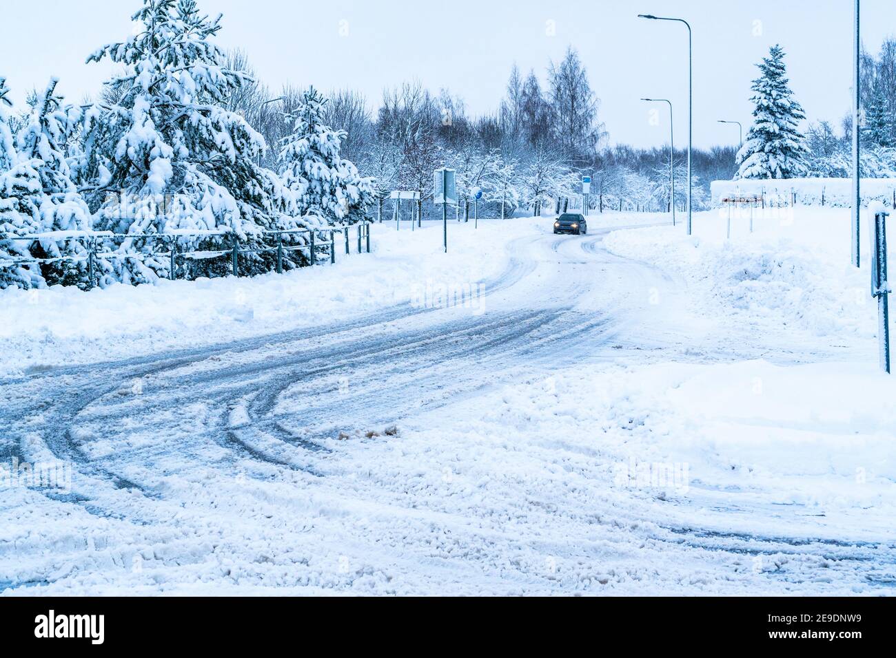 Driving a car on the road in winter city with snow covered trees. Snowy ...