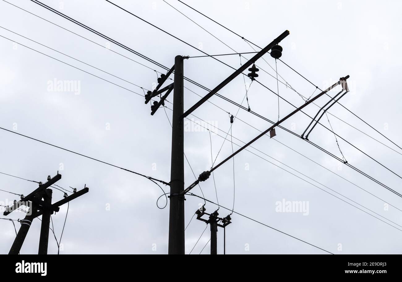 Overhead  railway power lines under cloudy sky background Stock Photo